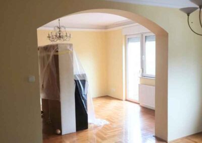 Felújított nappali boltíves átjáróval, frissen festett falakkal és parkettával